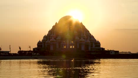 sun flare during sunset behind 99 dome mosque