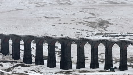 tomada aérea de un dron de lente larga del nevado viaducto de ribblehead en invierno en yorkshire dales, reino unido