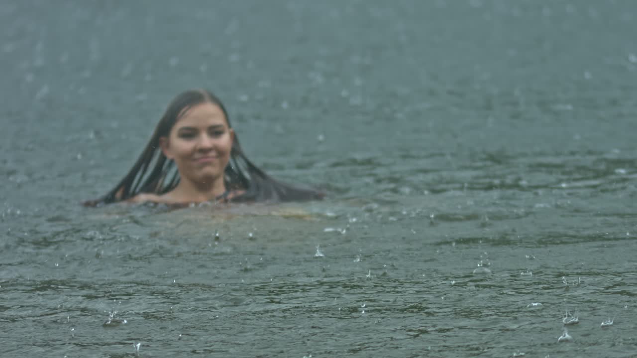 mujer nadando bajo la lluvia de verano