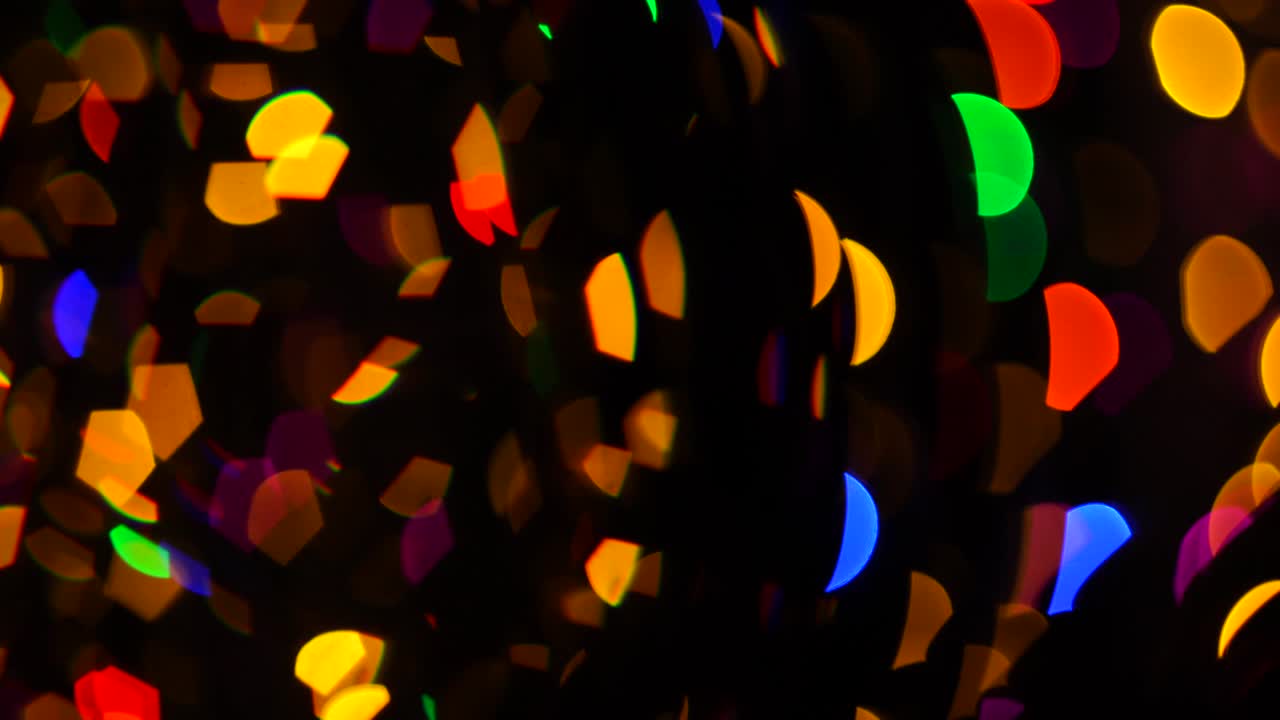 다채로운 크리스마스 추상적인 보케는 어두운 배경에서 아름답게 박이고 초점을 맞추지 않습니다.