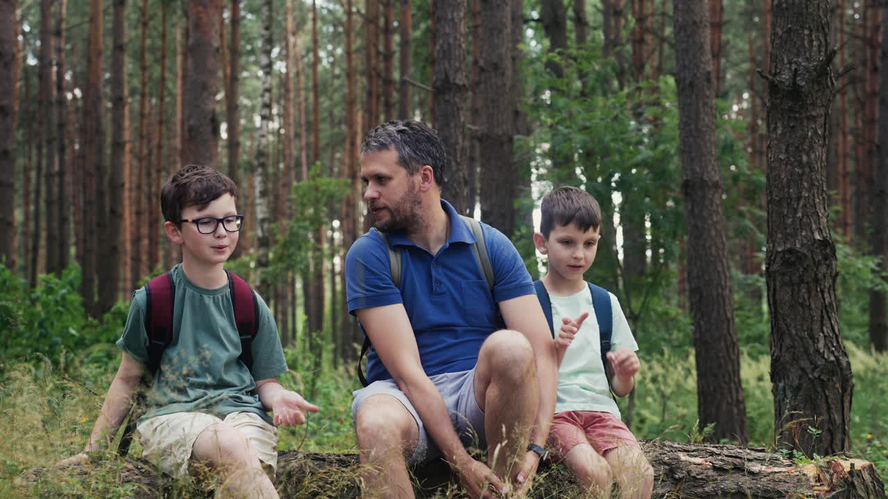 Family sitting on trunk at the forest