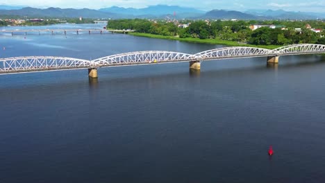 aerial establishing shot of commuters crossing the perfume river using the truong tien bridge