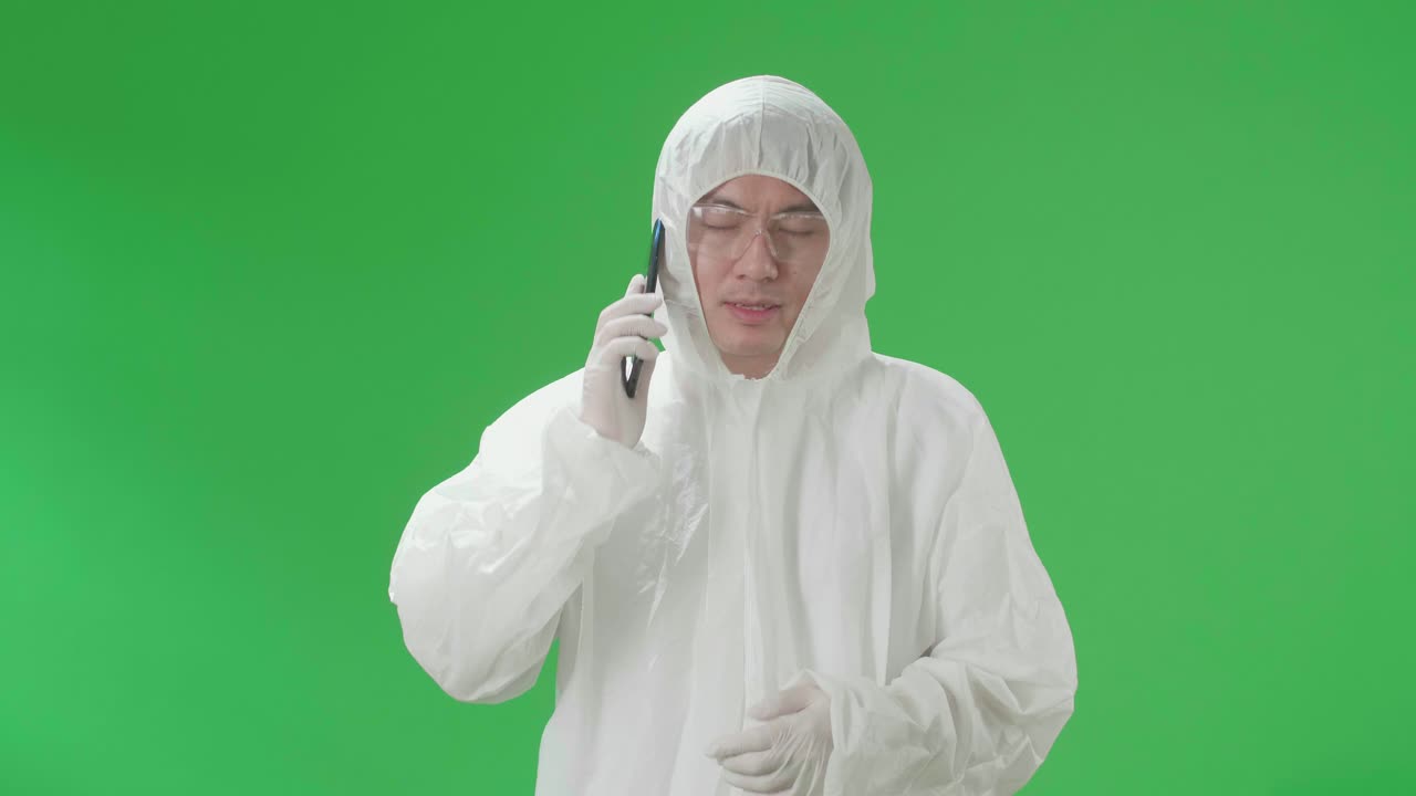 Orang Mengenakan Pakaian Pelindung Sedang Melakukan Panggilan Telepon