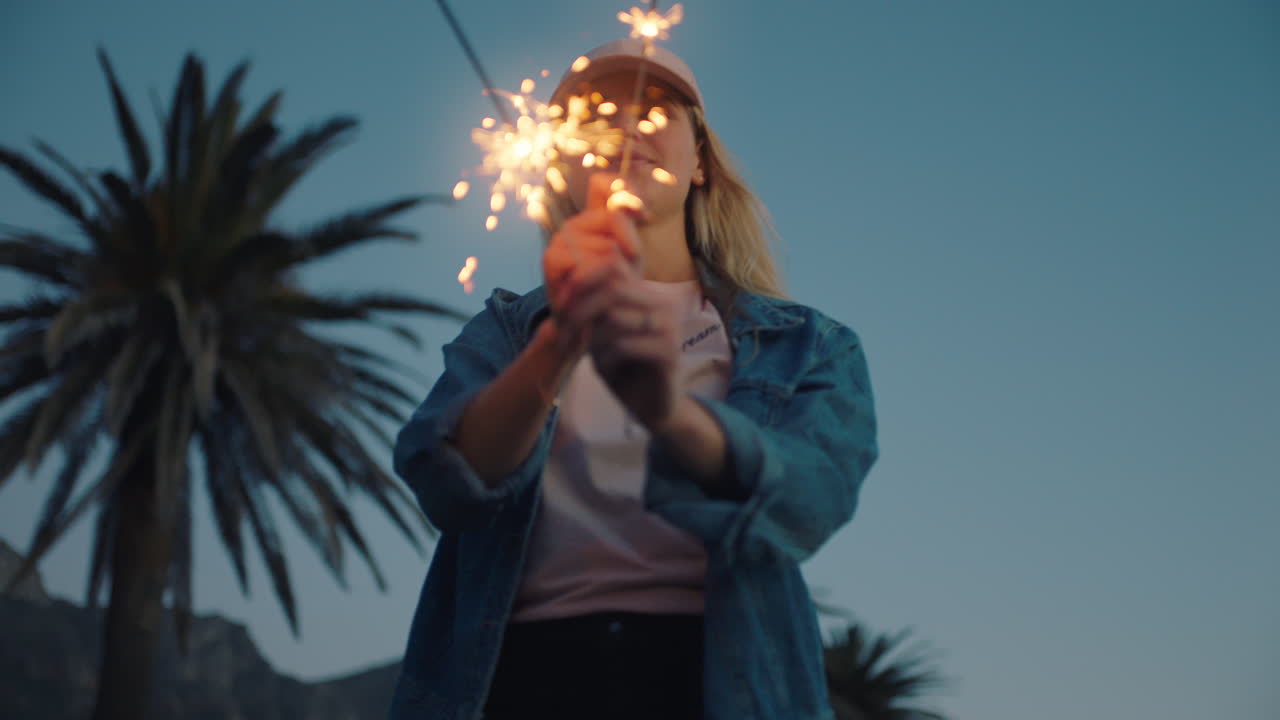feliz adolescente con bengalas bailando en la playa al atardecer celebrando la víspera de año nuevo divirtiéndose celebración del día de la independencia con fuegos artificiales disfrutando de la libertad