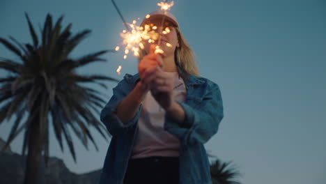 Fröhliches-Teenager-Mädchen-Mit-Wunderkerzen,-Das-Bei-Sonnenuntergang-Am-Strand-Tanzt-Und-Silvester-Feiert,-Spaß-Am-Unabhängigkeitstag-Mit-Feuerwerk-Hat-Und-Die-Freiheit-Genießt