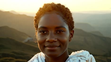 smiling woman in front of a mountain sunset