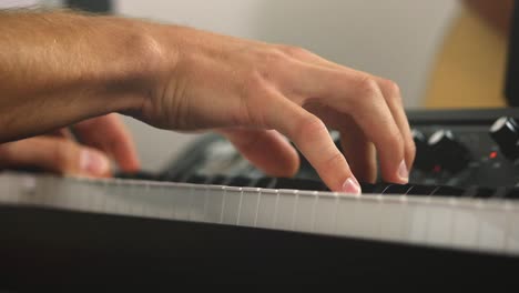 primer plano deslizante de un pianista profesional y teclas de pianos de escenario mientras toca acordes durante una sesión de grabación con un fondo brillante
