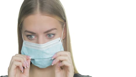 a woman struggles to breathe in her ppe mask and pulls it down to take a breath