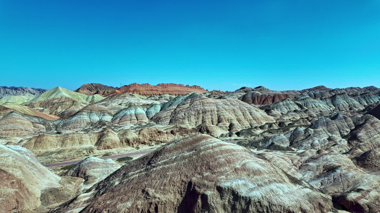 Zhangye, Gansu Province, China - Colorful, Layered Rock Formations Stretch Across the Landscape Under a Clear Blue Sky - Pan Shot
