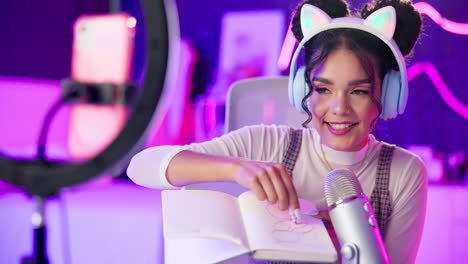 young woman recording a podcast or video while drawing