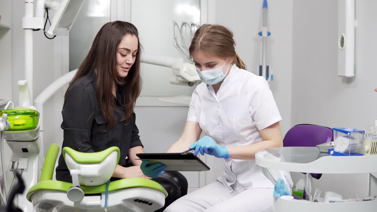 dentes saudáveis e cuidados dentários. médico dentista profissional confiante está mostrando dentes de raios-x em um tablet. dentista feminina com máscara e bata de laboratório.