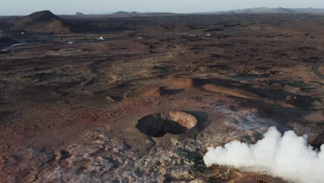 Géiser-Volcánico-Activo-Con-Vapor-Blanco-En-El-Accidentado-Paisaje-De-Islandia,-Aéreo