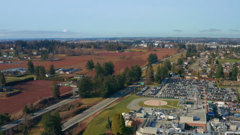 Fast-Drone-Orbits-a-Hospital-Helipad-by-a-Busy-Highway-on-a-Sunny-Day