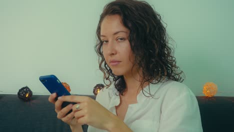 mujer usando un teléfono inteligente en un sofá