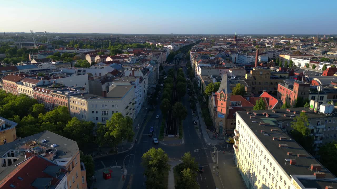 Elevated train navigating through a residential area in berlin, showcasing the city's urban transportation system. Amazing aerial view flight drone shot footage from above
