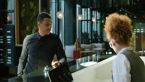 redheaded receptionist sitting behind the counter of a hotel