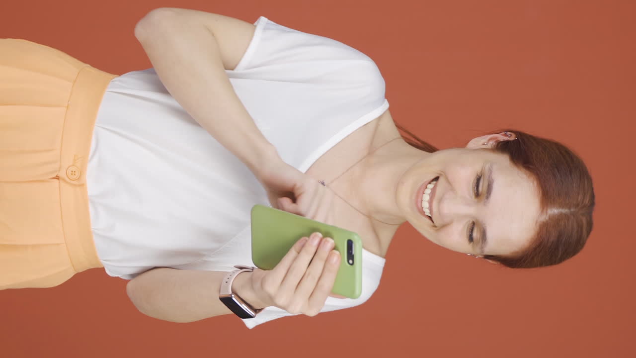 손에  ⁇ 드폰을 들고 춤추는 여성의 수직 비디오.