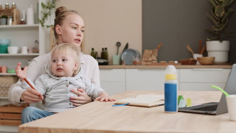 woman writing with child in arms