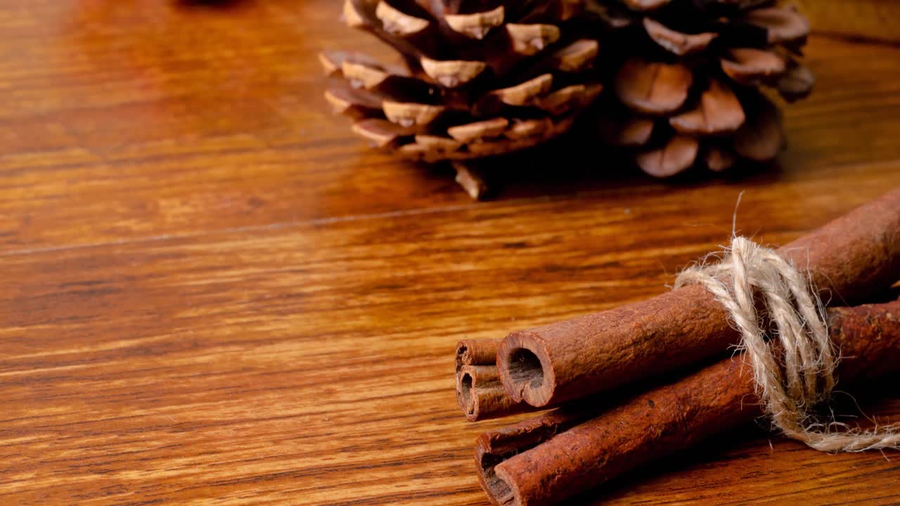 Composition of christmas decorations with cinnamon, pine cones on wooden surface