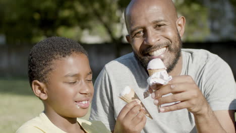 Vater-Und-Sohn-Essen-Eis,-Während-Sie-Im-Park-Spazieren-Gehen.