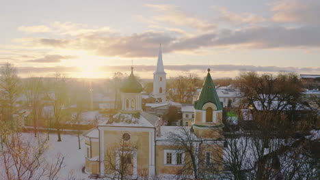 orthodox church and a lutheran church in winter sunset golden light