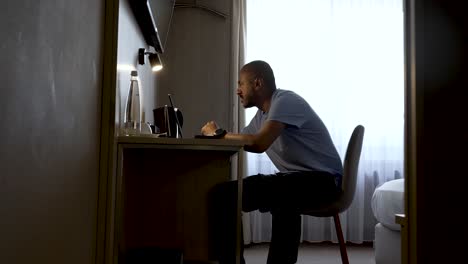 Shot-of-an-Asian-businessman-checking-his-laptop-from-his-home-reading-on-laptop