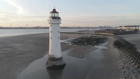 vista izquierda de la órbita aérea a través del faro británico y los rompeolas de la ciudad costera costera