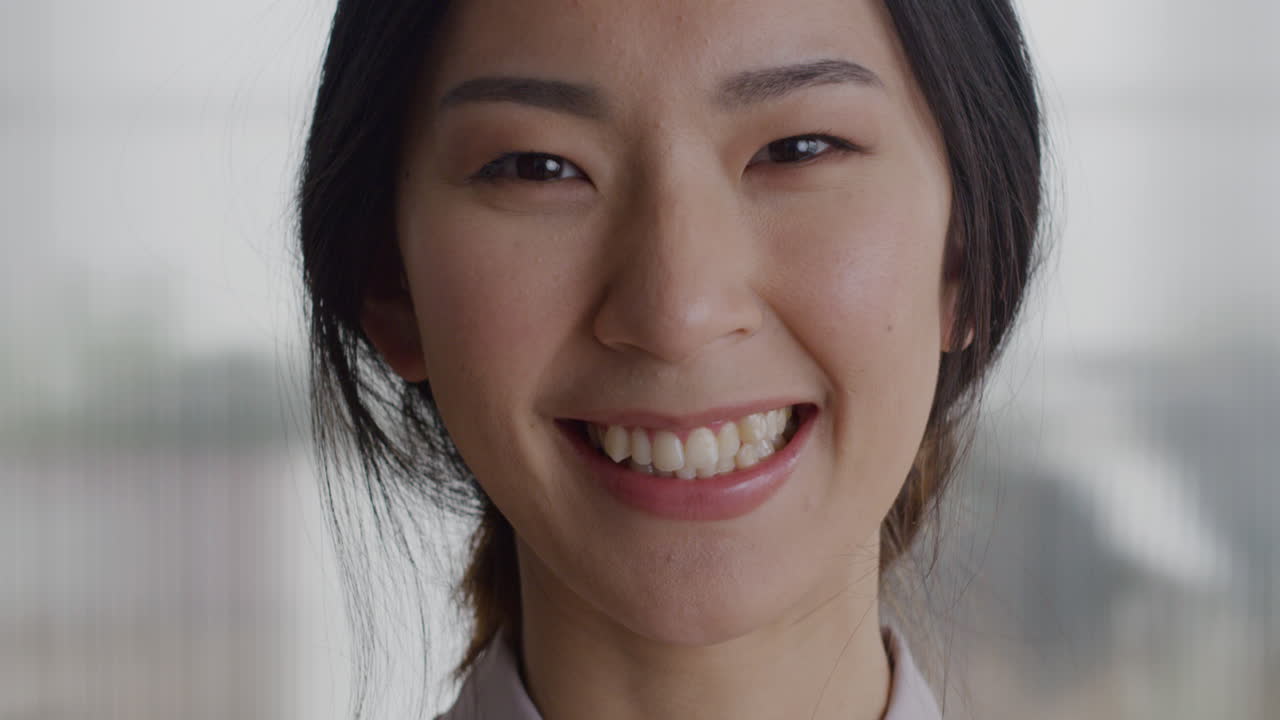 사무실 공간에서 행복하게 미소 짓는 아름다운 아시아 여성의 초상화