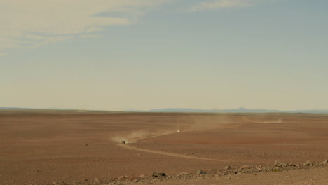 öde-Landschaft,-Einsames-Autofahren,-Dahinter-Eine-Staubwolke