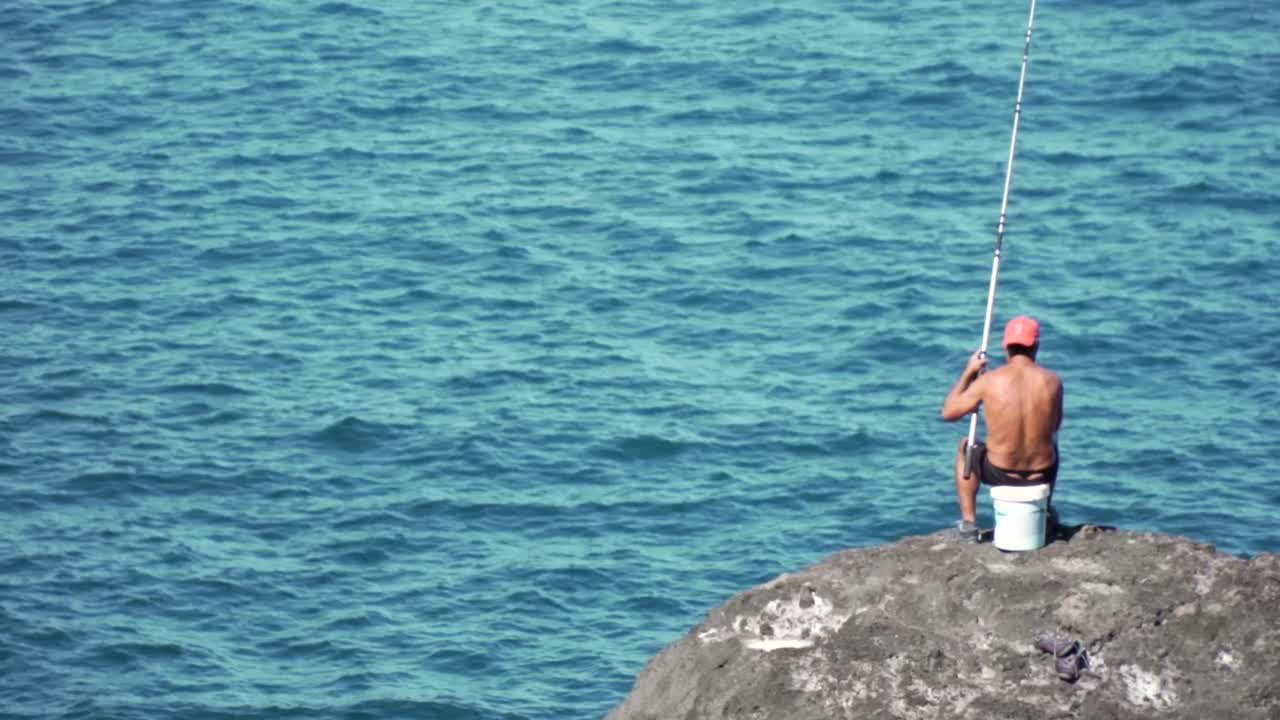 Pescatore su una roccia sull'oceano