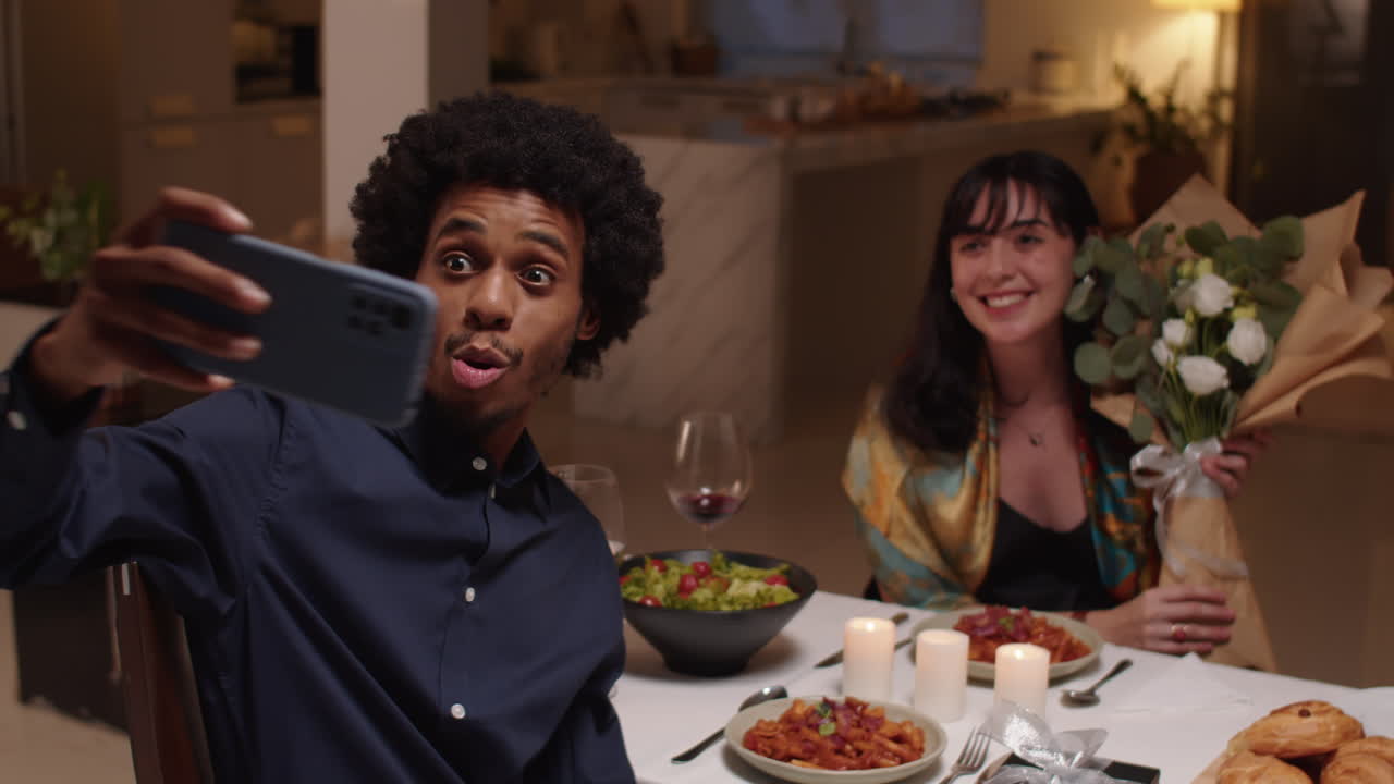Biracial Couple Taking Selfie on Smartphone by Served Table