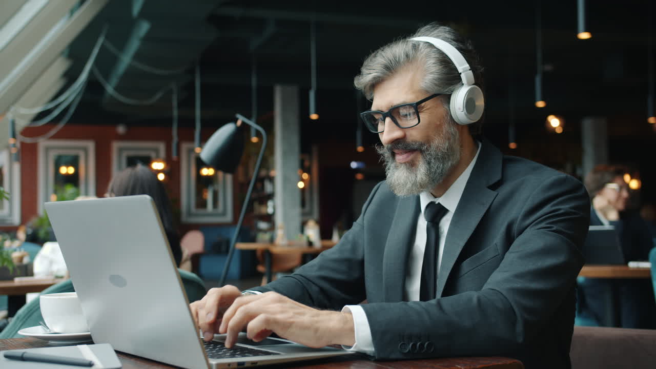 Forretningsmand arbejder på bærbar computer på en café