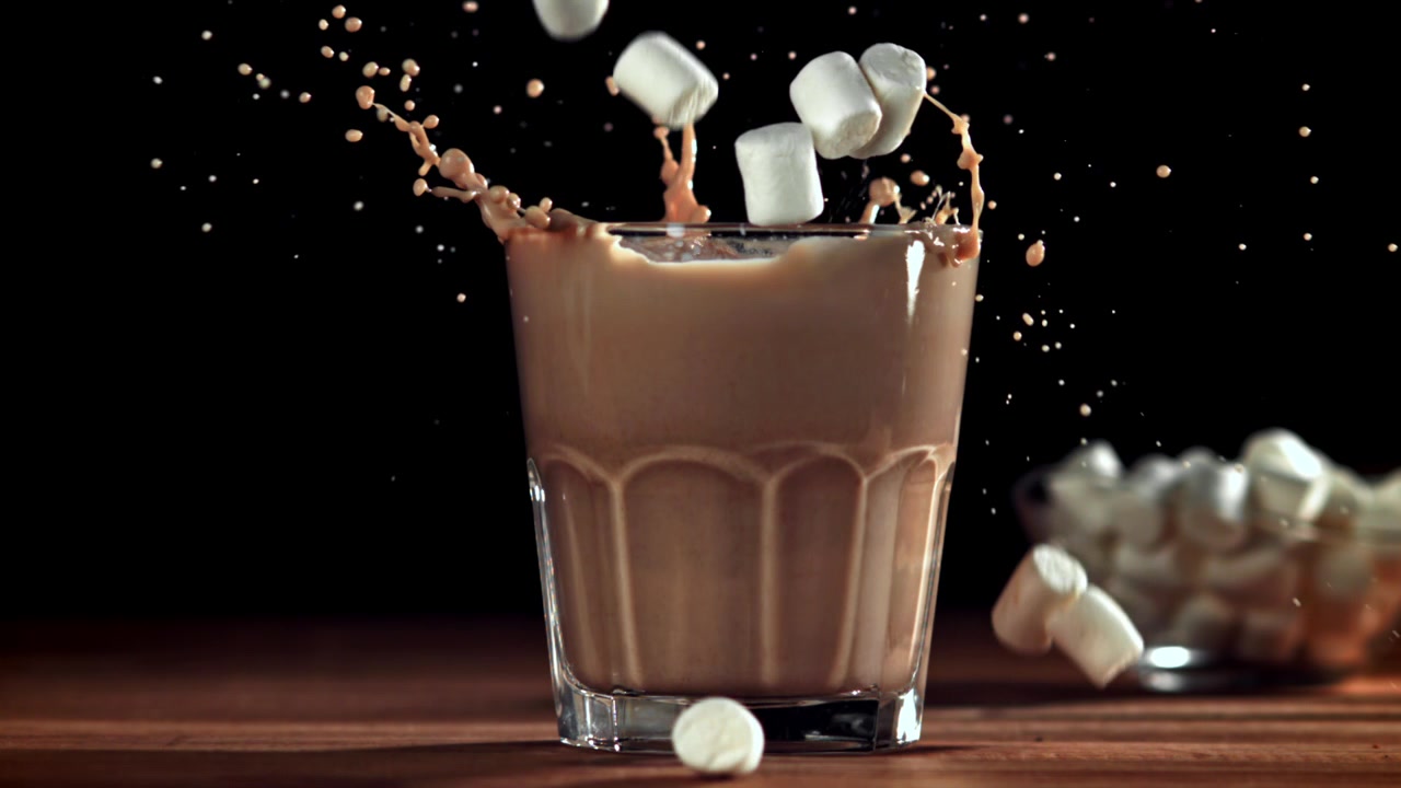 Marshmallows che si tuffano in un bicchiere di latte al cioccolato al rallentatore
