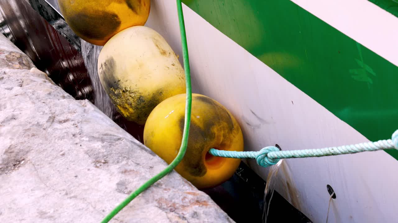 배가 배수되는 동안 배의 방어용 노란색 부표의 정적 근접