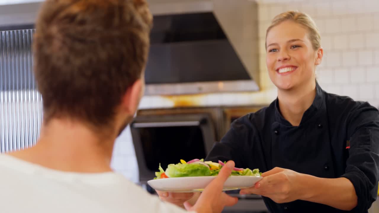 Waitress serving food to customer 4k