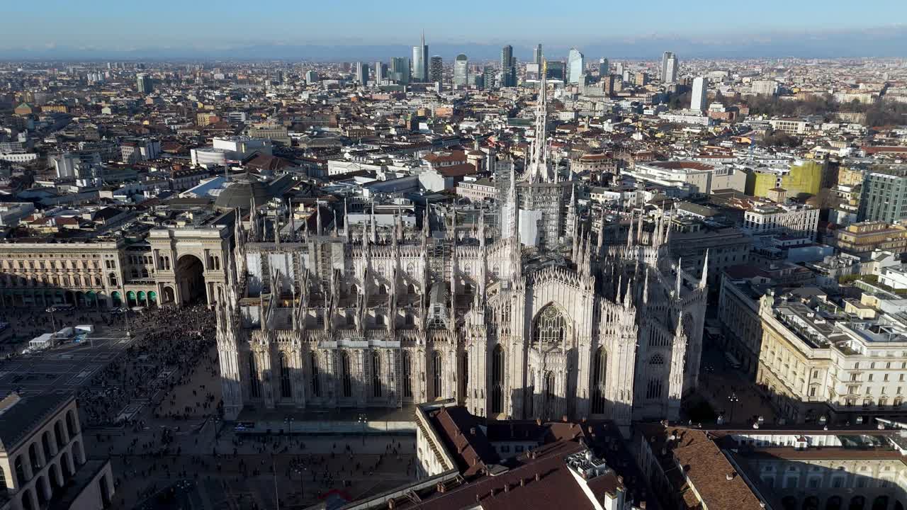 drone reveal Milan cityscape skyline with Duomo cathedral downtown in foreground during a sunny day of summer