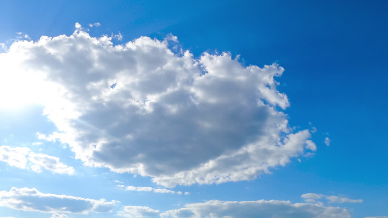 Wonderful light clouds against beaming sun. Cloudscape formation timelapse on fantastic summer day.