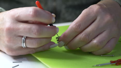 Close-up-shot-of-woman-pushing-spring-bar-of-watch-on-table