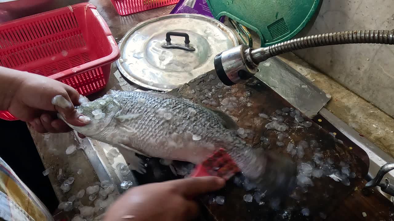 descascado y limpieza secuencial de peces en un fregadero