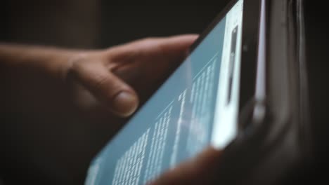 shooted in slow motion showing man's hands browsing social media or playing with a mobile tablet at evening