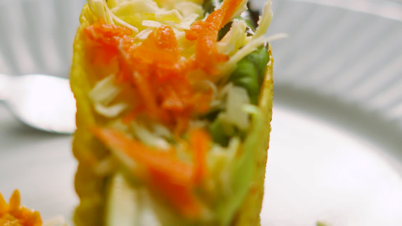 Slow Moving Shot Over Delicious Fresh Mexican Taco Made from Crispy Corn Tortilla Filled with Variety of Ingredients including Beef, Lettuce, Carrot, Tomatoes and Cheese. Latin American Cuisine