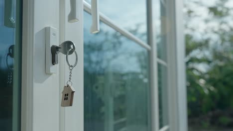 landlord for house concept. the house key for unlocking a new house is plugged into the door. the wooden keychain was moving as the wind blew.