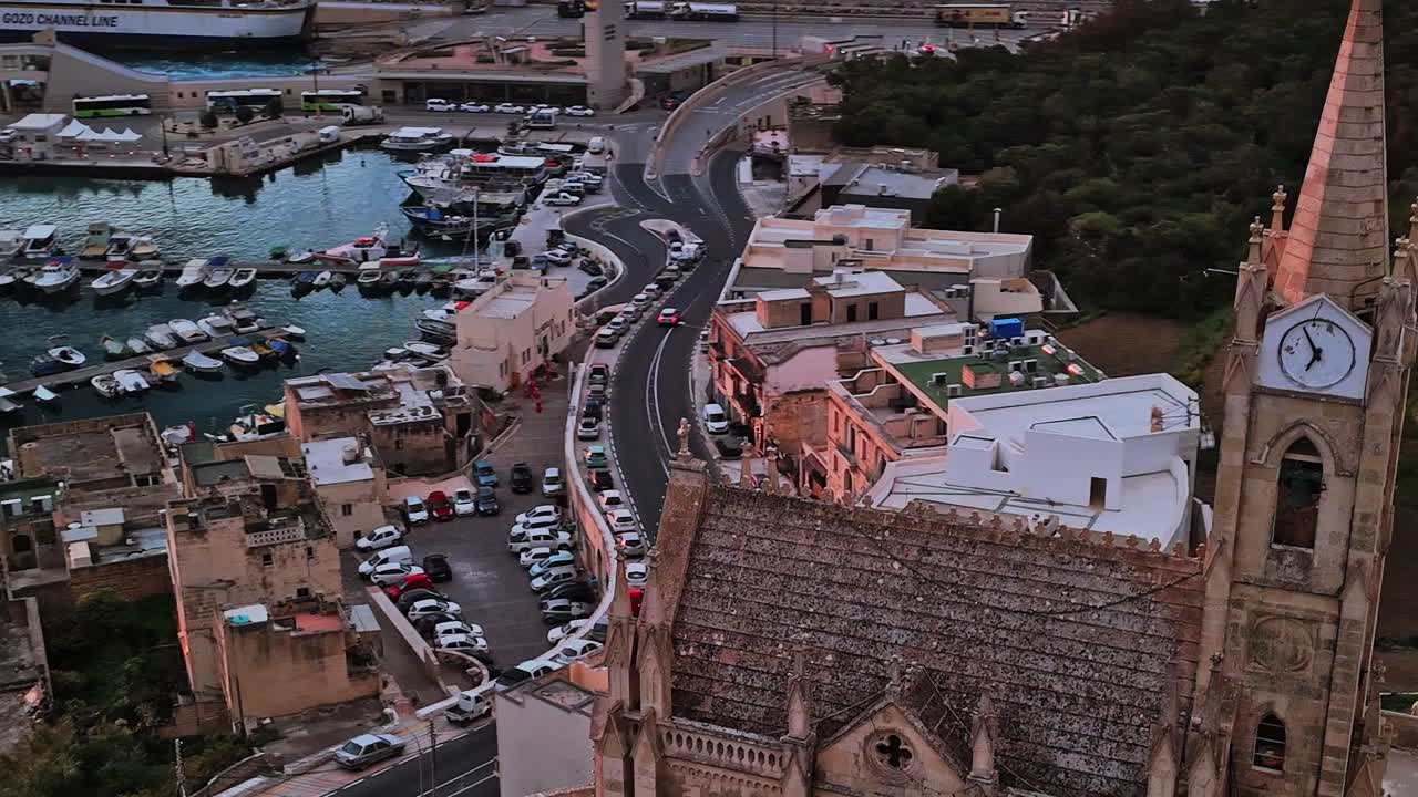 Historisk arkitektur och slingrande vägar i Malta under solnedgången