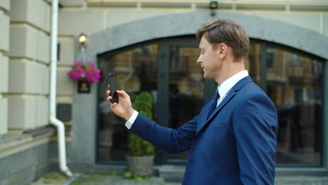 Smiling-business-man-having-video-conference-online-outdoors.