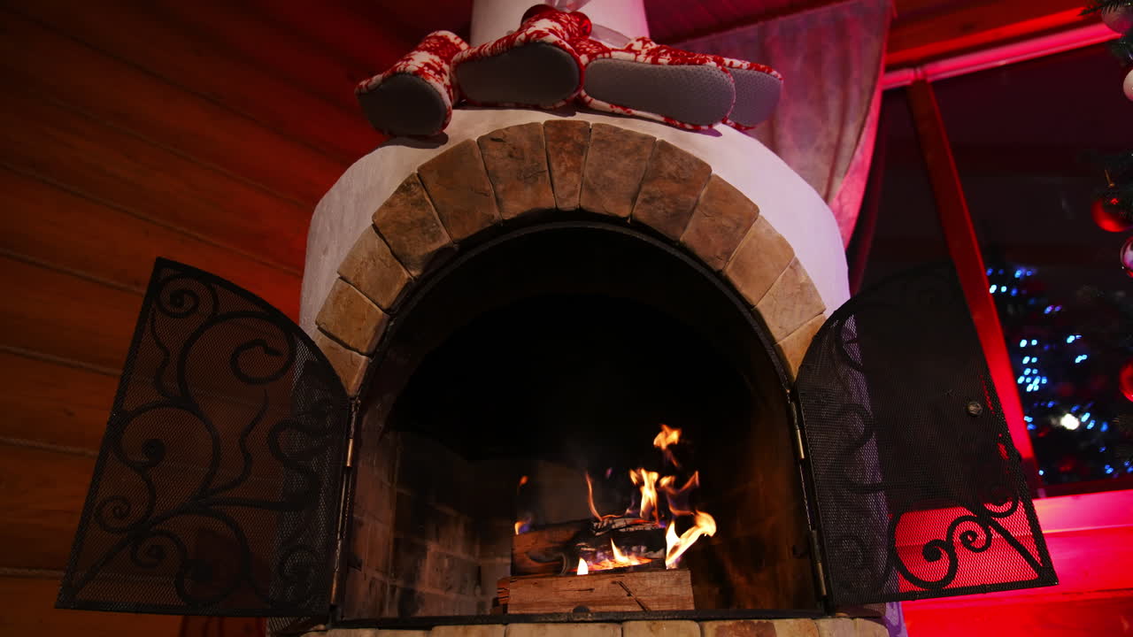 Warm fireplace at Christmas holidays. Wood burning in a beautiful brick fireplace. Cosy atmosphere at home. Home comfort in winter.