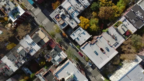 Los-Pájaros-Aéreos-Miran-Desde-Arriba-Hacia-Abajo-La-Vista-Panorámica-De-Las-Hileras-De-Casas-Divididas-Por-Calles-Y-El-Colorido-Follaje-Otoñal-De-Los-árboles.-Manhattan,-Ciudad-De-Nueva-York,-Estados-Unidos