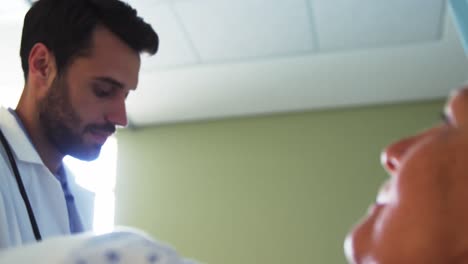 male doctor showing medical report to senior woman on digital tablet