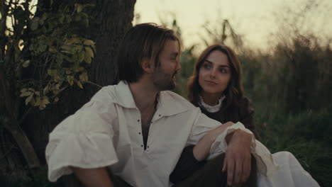 romantic couple in period attire resting outdoors