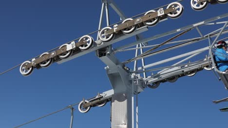 cable car wheels atop of a steel tower against blue sky background, close up