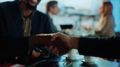 business people shaking hands in airport lounge